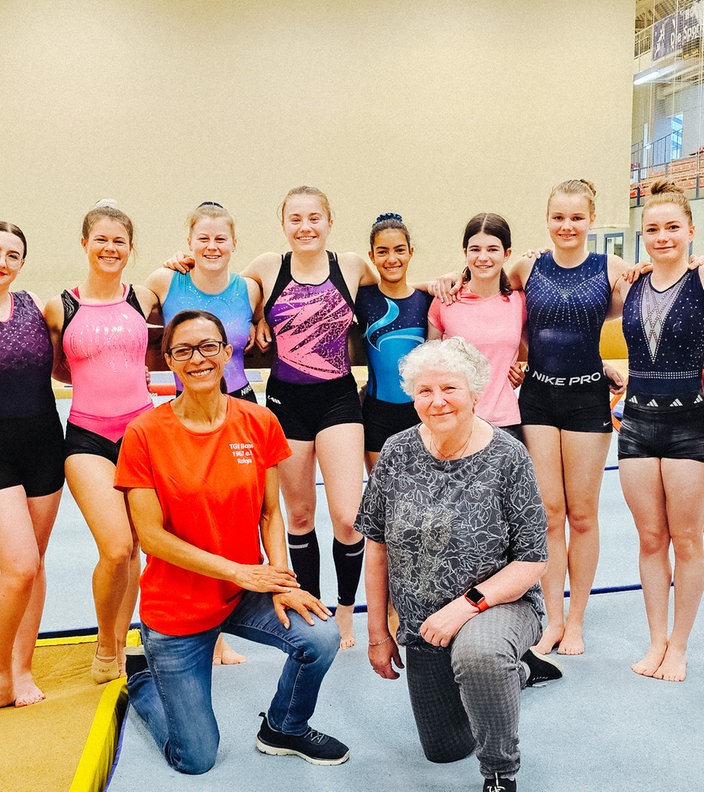 Eine Gruppe Frauen posiert in Sportkleidung.