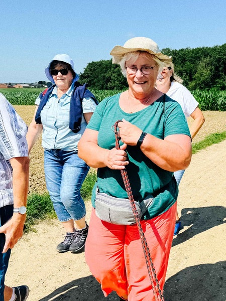 Die Teilnehmenden des Trauerspaziergangs gehen über einen Feldweg.