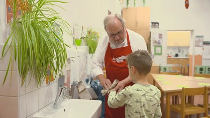 Wilfried Steinkamp ist in der Küche und wischt einem Kind die Hände ab