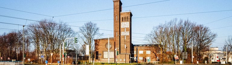 Eine Kirche an einer Straße, die von Bäumen umgeben ist 