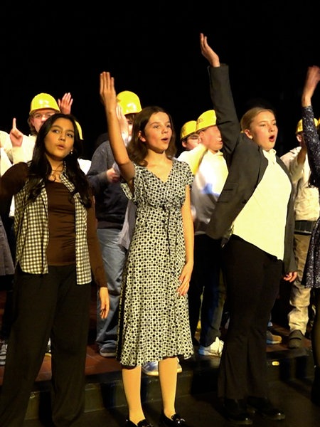 Achtklässler singen im Ensemble auf der Bühne