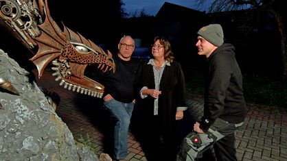Christian Vlasak und seine Eltern betrachten den Drachen auf dem Grundstück