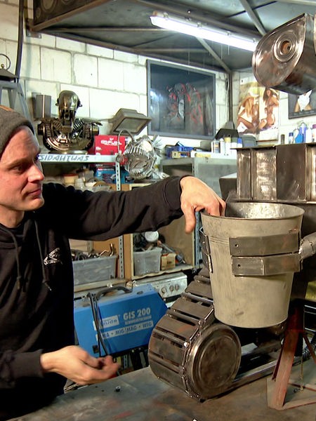 Christian Vlasak steht in seiner Werkstatt und baut an seinem "Wall-E"