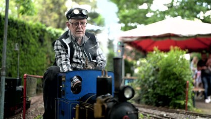 Ulrich Bettenworth aus Oberhausen fährt auf seiner blauen Gartenbahn durch seinen Garten