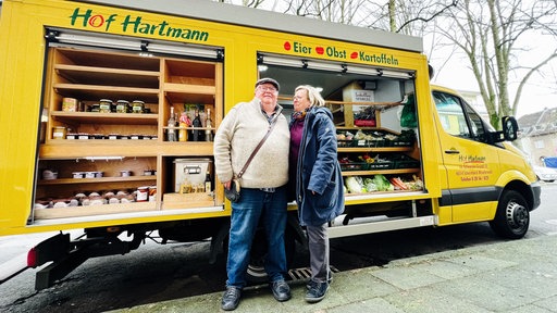 Josef und Heike Hartmann stehen vor ihrem mobilen Hofladen-Wagen.