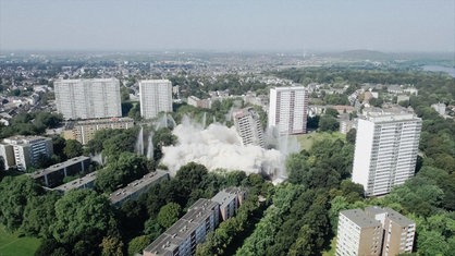 Ein weißes Hochhaus stürzt nach einer geplanten Sprengung ein