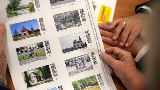 Hände halten einen Briefmarkenbogen 