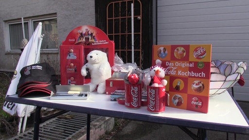 Tisch mit Fanartikel von Coca-Cola auf dem Dorf-Trödelmarkt in Soest-Ampen