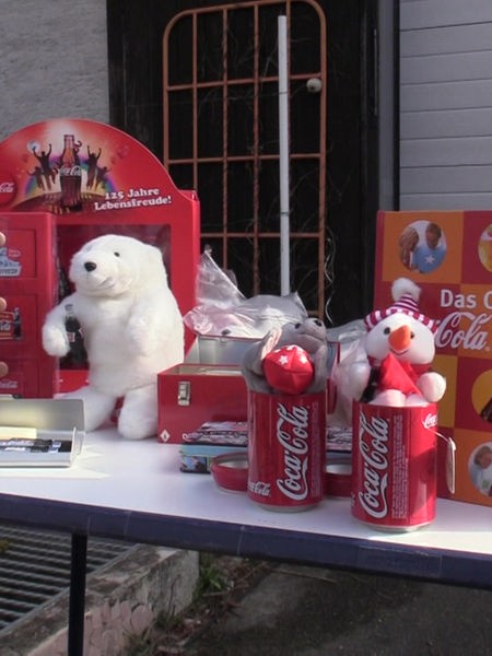 Tisch mit Fanartikel von Coca-Cola auf dem Dorf-Trödelmarkt in Soest-Ampen