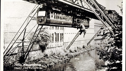 Fotomontage von einem Elefanten, der aus der Schwebebahn in die Wupper springt. Unten links ist "Tuffis Wuppersprung. Gruss aus Wuppertal" zu lesen.