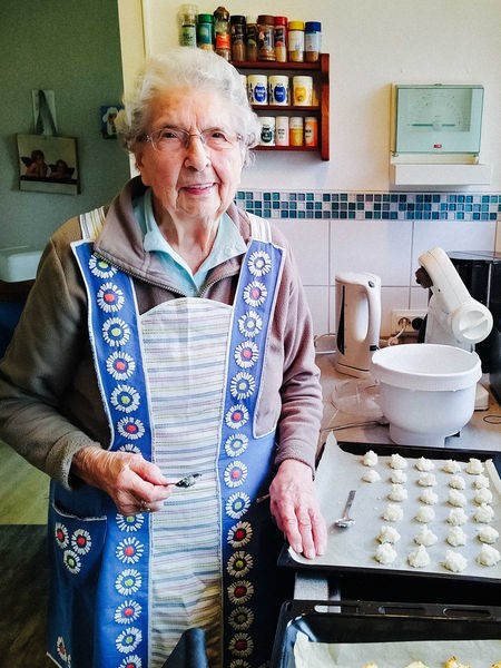 Die 110-jährige Elisabeth Rüterbories sitzt mit Blumen in der Hand vor einem gedeckten Tisch