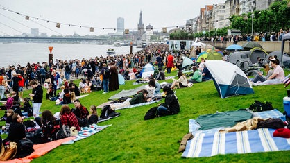 Zahlreiche Besucher des Japantags in Düsseldorf nutzen die Wiesen am Rhein