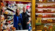 Linda und Christoph Ekamp stehen in ihrem Kiosk. Um sie herum sind allerlei Süßwaren ausgelegt.