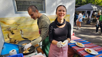 Eine Frau und ein Mann machen Arepas: belegte kolumbianische Maisfladen
