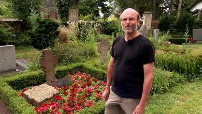 "Beiermann" Norbert Schumacher steht auf dem Friedhof der Kirche Sankt Martinus in Köln-Esch