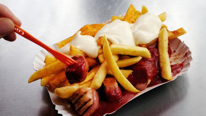 Eine Schale mit einer Currywurst und Pommes weiß