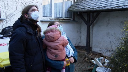 Familie Opladen vor ihrem zerstörten Haus in Mechernich-Kommern