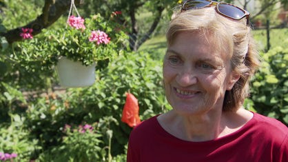 Bezirksbürgermeisterin Claudia Greven-Thürmer steht in einer Kleingartenanlage