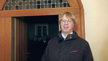 Pfarrer Rehrmann steht vor der Eingangstür der Stadtkirche
