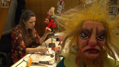 Silke Essert malt in der Werkstatt des Puppentheaters Hänneschen in Köln einer Holzpuppe die Hand an