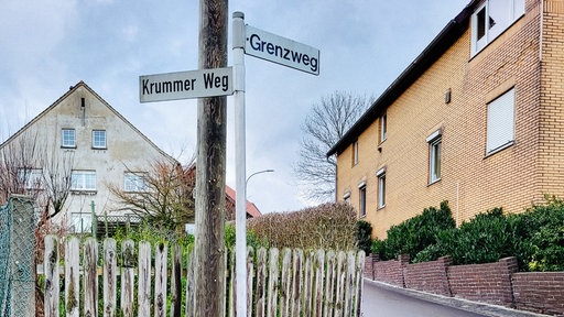 Ein Schild mit zwei verschiedenen Straßennamen