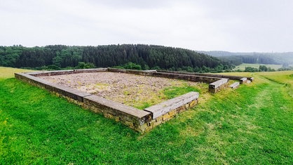 Rekonstruierte Grundrisse eines römischen Hauses, darum eine Wiese