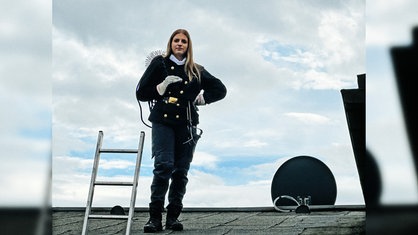 Schornsteinfeger-Azubi Jolina Schneider steht auf einem Dach