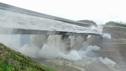 Die Südbrücke der Talbrücke Eisern bei Siegen stürzt während der Sprengung zur Seite