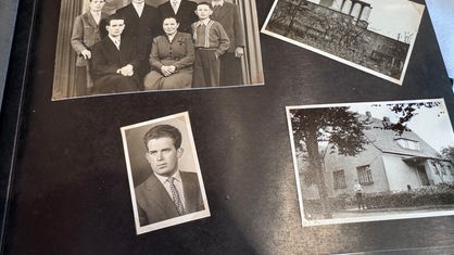 Ein altes Fotoalbum mit Schwarz-Weiß-Aufnahmen. Es ist ein Bild von einem Haus, einer Familie und einem jungen Mann zu sehen