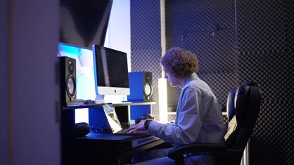 Ein junger Mann sitzt am Rechner.