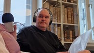 Ein Mann mit Kopfhörern und Aufnahmegerät