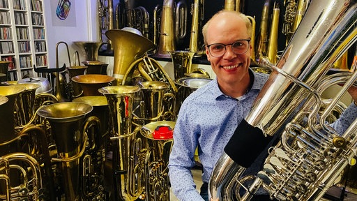 Daniel Ridder mit einer Tuba in seinem Musikzimmer