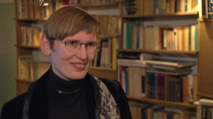 Eva von Redecker steht vor einem Bücherregal