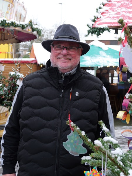 Michael Karp-Decker steht lächelnd auf dem Weihnachtsmarkt in Solingen