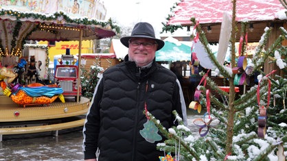 Michael Karp-Decker steht lächelnd auf dem Weihnachtsmarkt in Solingen