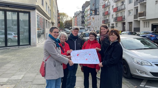 Sechs Mitglieder der Interessensgemeinschaft Vinzerweedel halten gemeinsam einen Stadtplan in die Kamera