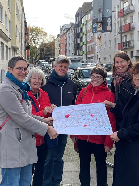 Sechs Mitglieder der Interessensgemeinschaft Vinzerweedel halten gemeinsam einen Stadtplan in die Kamera