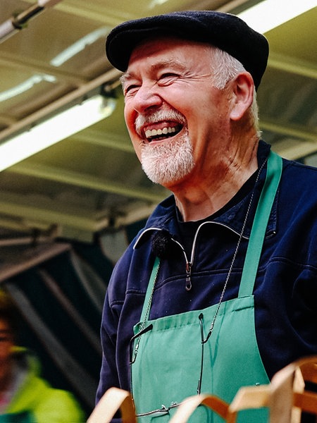 Siegfried Schling steht in seinem Gemüsestand und lacht.