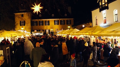 Viele Menschen auf einem Weihnachtsmarkt im Schlosshof