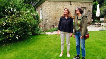 Zwei Frauen stehen auf einer Wiese im Schlossgarten