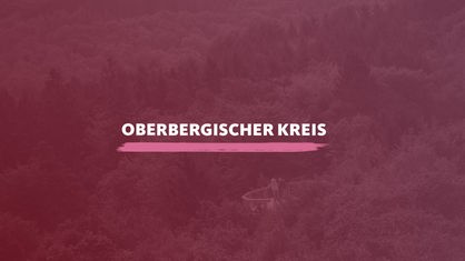 Der Blick von oben auf die bergige Waldlandschaft im Oberbergischen Kreis. Darauf der Schriftzug "Oberbergischer Kreis".
