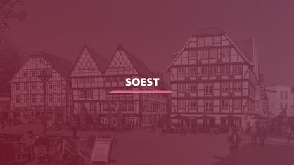 Der Blick auf den Marktplatz im Stadtkern von Soest mit Fachwerkhäusern im Hintergrund. Darauf der Schriftzug "Soest".