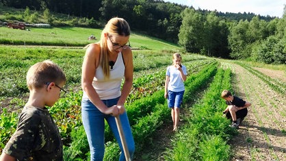 Carina Schweitzer-Koch hilft den Nachbarskindern bei der Ernte.