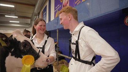 Jona Neuber und Josefa Henkelmann stehen neben Rind Elsa und freuen sich über den ersten Platz beim Vorführwettbewerb