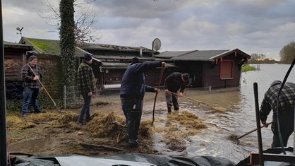 Freiwillige Helfer unterstützen Landwirt Tobias Beermann beim Schutz seines Hofes vor der Überflutung