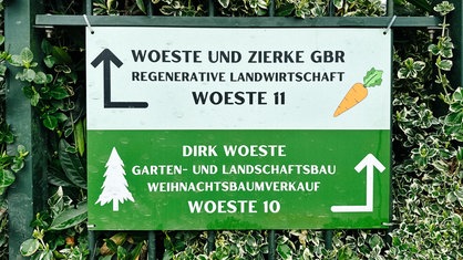 Ein Schild am Hof Woeste in Lüdenscheid mit Wegweisern zum Gelände der Landwirtschaft und zum Gelände des Gartenbaubetriebs