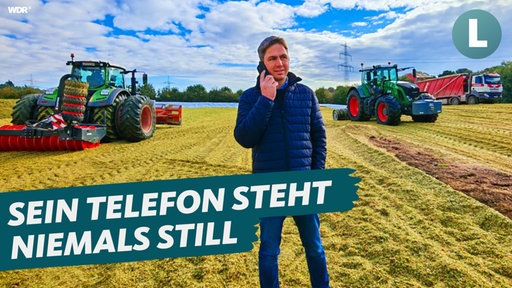 Tobias Schafmeister steht mit dem Handy am Ohr auf einem Feld.