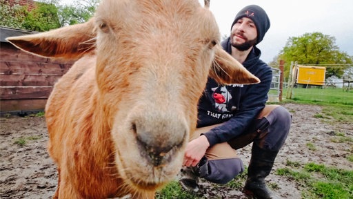 Markus Steudler und eine Ziege gucken in die Kamera