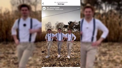 Ausschnitt aus Instagram: Die drei Brüder tanzen eingehakt auf einem halb abgeernteten Maisfeld