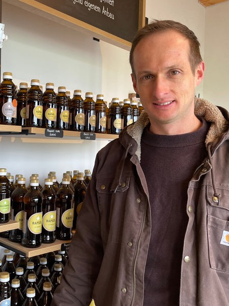 Landwirt Andreas Becker steht im Hofladen vor seinem selbstgepresstem Hanföl